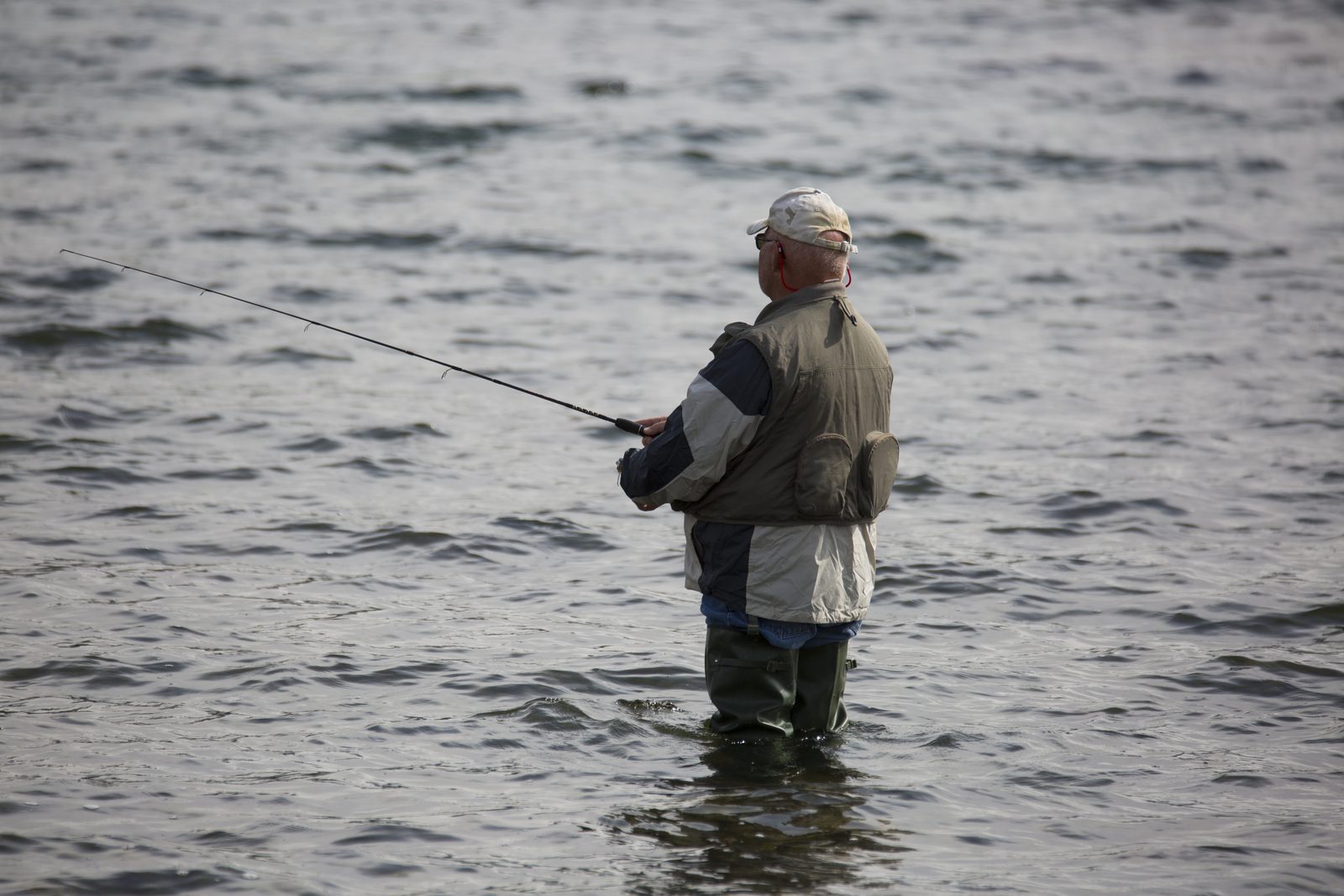 Angler fishing from a lake shore